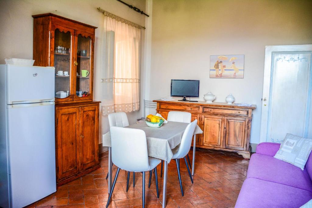 Sala da pranzo luminosa con tavolo, arredi in legno e pavimento in cotto.