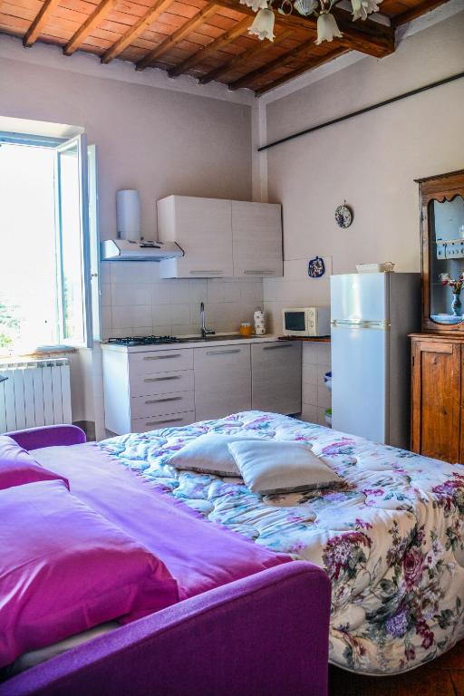 Soggiorno con divano letto aperto e angolo cottura, con soffitto a travi in legno.